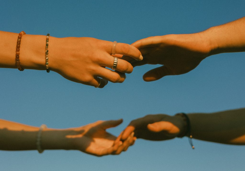 Couples' hands with sky in background
