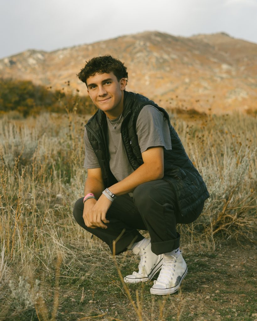 Senior male portrait squatted in front of mountains